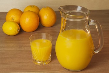 Domestic fresh orange juice in a glass jar on a wooden table. Hand-prepared homemade orange juice. Healthy drink for athletes. Place for your text. Sales of juices.
