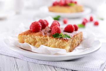 Fresh pie with raspberry in white plate on wooden table, closeup