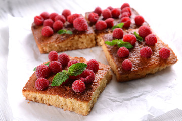 Fresh pie with raspberry on parchment on wooden table, closeup