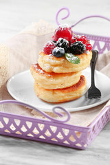Fritters of cottage cheese with berries in plate, closeup