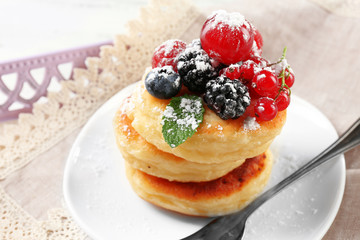 Fritters of cottage cheese with berries in plate, closeup