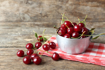 Cherries in bowl, on wooden background
