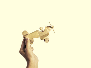 isolated image of a hand holding a wooden aircraft handmade