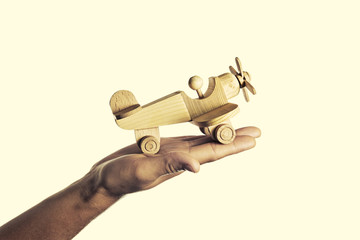 isolated image of a hand with an open palm on which the handmade wooden aircraft