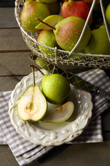 Ripe tasty pears in basket on table close up