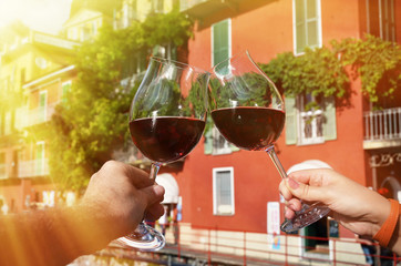 Two wineglasses in the hands. Varenna town at the lake Como, Italy