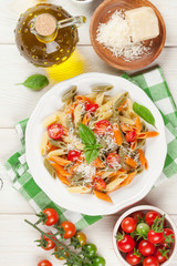 Colorful penne pasta with tomatoes and basil