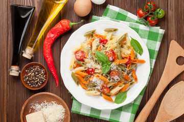 Colorful penne pasta with tomatoes and basil
