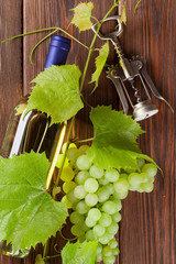 Bunch of grapes, white wine and corkscrew