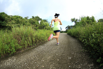 young fitness woman trail runner running on seaside mountain