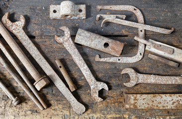 Rusted old mechanical tools well sorted on the bench wooden work