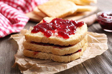 Bread with butter and homemade jam on crumpled parchment, closeup