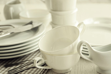Fototapeta na wymiar Set of white ceramics dishes on wooden table, closeup