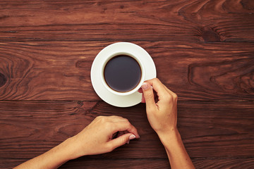 woman holding cup of black coffee