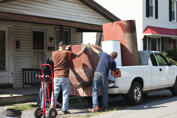 Men loading heavy scrap metal into truck