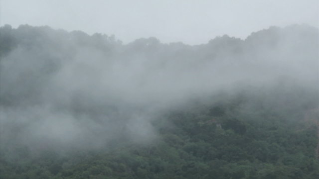 Fog rolls across a mountaintop.