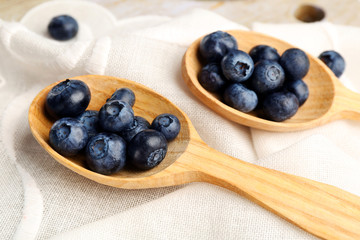 Fresh blueberries in spoons on table close up