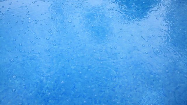 
Raindrops are broken with splashes falling on the surface of the water