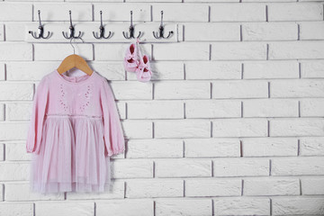 Child dress on hanger on white wall background