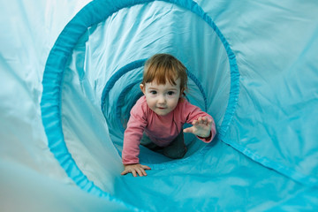 Small toddler playing in a tunnel tube