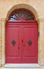 Red door with black iron knobs