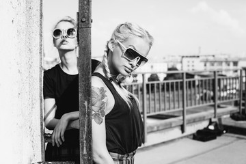 Fototapeta na wymiar two pretty hipster sisters against urban white wall