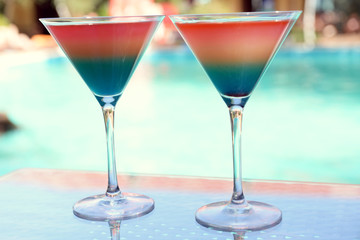 Cocktails on swimming pool background