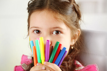 Cute little girl with colorful crayons, close-up