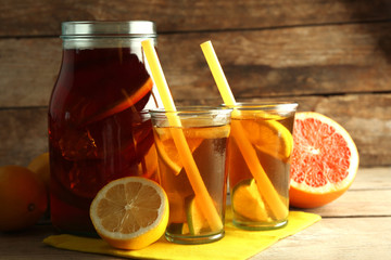 Iced tea with lemon and grapefruit on wooden background