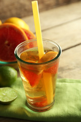 Iced tea with lemon and grapefruit on wooden background