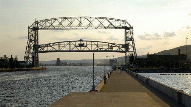 Time lapse of ship passing under lift bridge and bridge going back down.