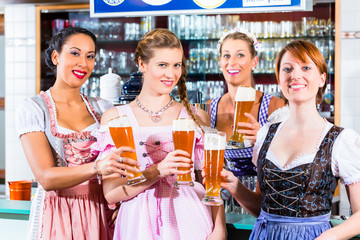 Wirtin und Gäste trinken Bier in bayerischem Lokal