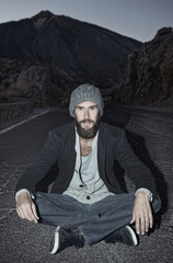 Road to heaven / Young man is sitting in the middle of a street