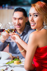 Asian friends dining in fancy restaurant