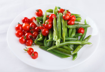 Peppers green beans with cherry tomatoes. Salad on a white background.