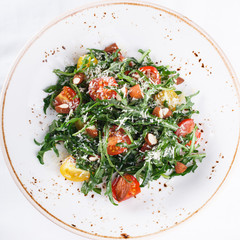 Salad cherry tomatoes with arugula and Parmesan.selective focus