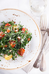 Salad cherry tomatoes with arugula and Parmesan.selective focus