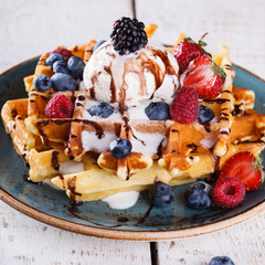 Belgian waffles with ice cream,fresh berries and chocolate sauce.