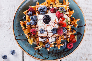 Belgian waffles with ice cream,fresh berries and chocolate sauce.
