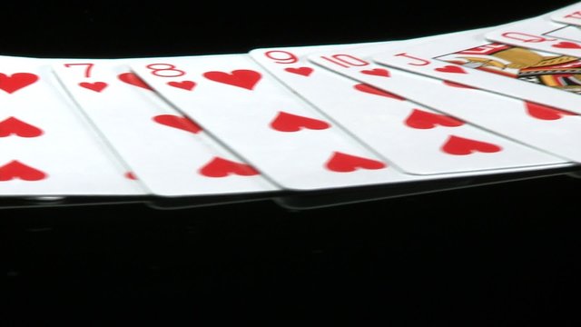 A deck of cards laid out rotates in front of a camera.