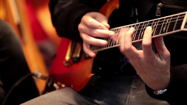 Professional guitarist playing electric guitar close up process 