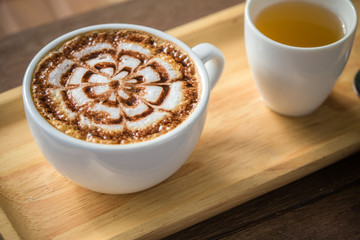 Latte Coffee art on the wooden desk with tea cup