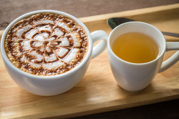 Latte Coffee art on the wooden desk with tea cup