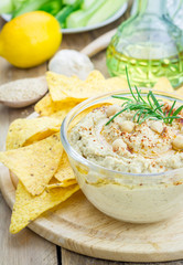 Bowl of classic hummus sprinkled with paprika and sesame, served with tortilla chips