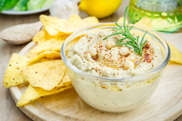 Bowl of classic hummus sprinkled with paprika and sesame, served with tortilla chips
