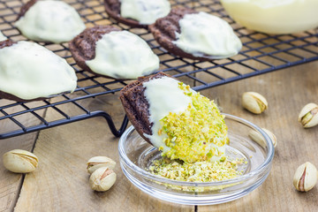 Dark chocolate madeleines covered with white chocolate and pistachio