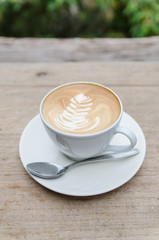 Cup of hot coffee latte art on wood table
