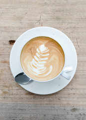 Cup of hot coffee latte art on wood table