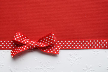 Red ribbon bow on paper