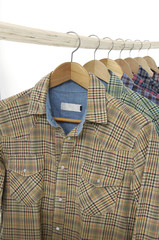 From view Variety of Men's different sleeved plaid cotton on a wooden hanger